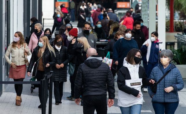 Un grupo de personas pasea por las inmediaciones de un centro comercial en Cataluña durante la segunda oleada de casos de coronavirus que ha puesto en duda el futuro plan de Navidad. EFE/Enric Fontcuberta