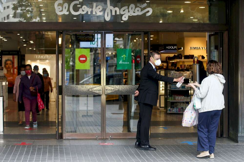 El Corte Ingles irrumpe en el sector hotelero con la reforma de dos edificios vacíos de Madrid. En la imagen, un trabajador de El Corte Inglés suministra gel hidroalcohólico a una clienta. EFE/Archivo