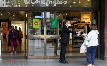 El Corte Ingles irrumpe en el sector hotelero con la reforma de dos edificios vacíos de Madrid. En la imagen, un trabajador de El Corte Inglés suministra gel hidroalcohólico a una clienta. EFE/Archivo