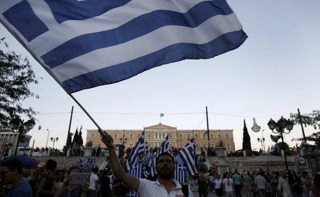 Un hombre ondea una bandera en Grecia./ EFE