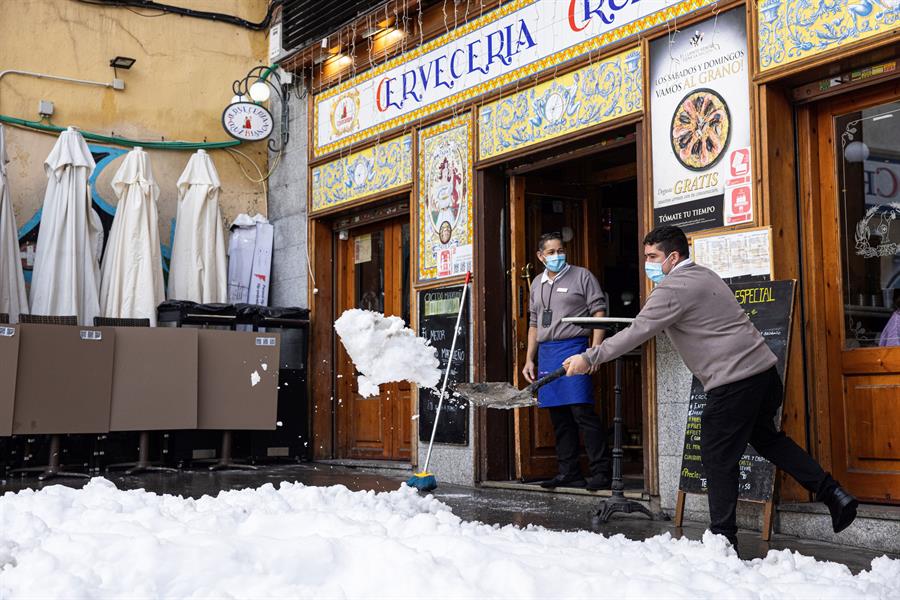 Personal de hostelería limpian de nieve las terrazas de los establecimientos en Madrid, este domingo. EFE/Rodrigo Jiménez