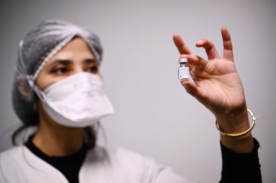 Una enfermera sostiene un frasco con la vacuna de Pfizer / EFE