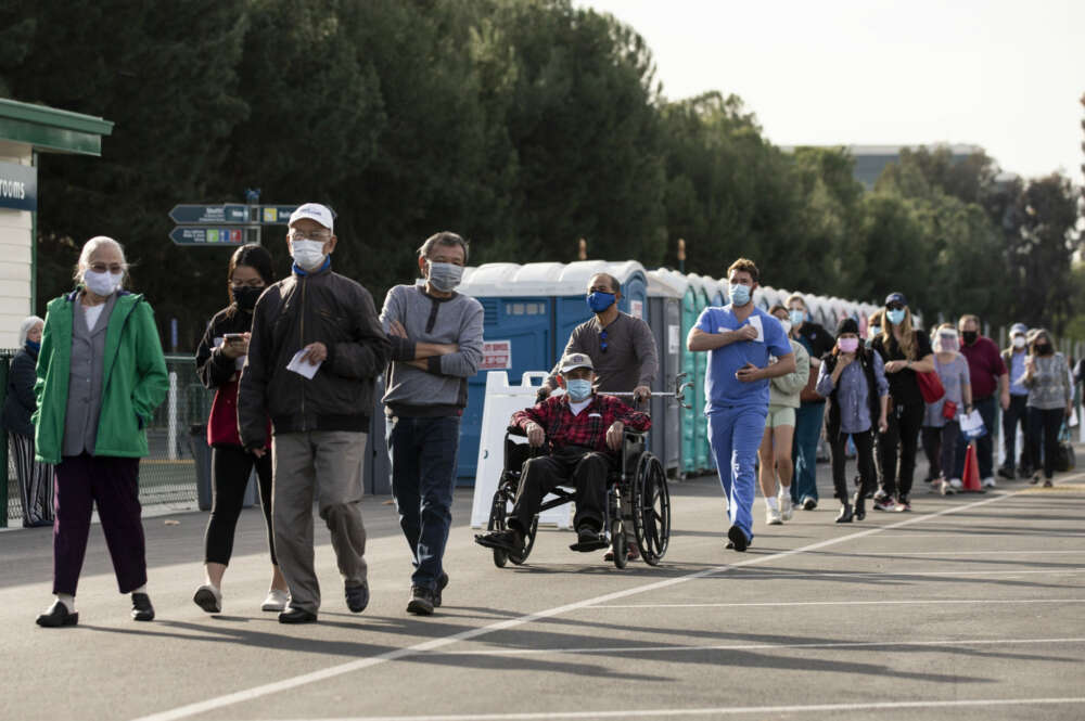 Personas hacen fila para recibir la vacuna contra la covid-19 en Disneyland, de Anaheim, California, este 13 de enero de 2021. EFE/Etienne Laurent