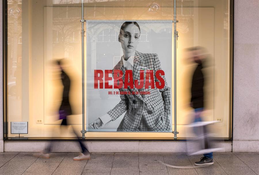 Unas personas pasan ante unos grandes almacenes de Zaragoza en el arranque de las rebajas. EFE/Javier Cebollada