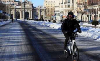 Un hombre circula con una bicicleta del servicio municipal bicimad por calle Alcalá este lunes, tras el paso de la borrasca Filomena. EFE/Fernando Alvarado