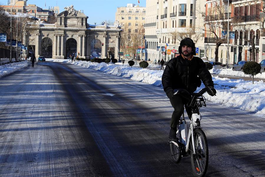 Un hombre circula con una bicicleta del servicio municipal bicimad por calle Alcalá este lunes, tras el paso de la borrasca Filomena. EFE/Fernando Alvarado