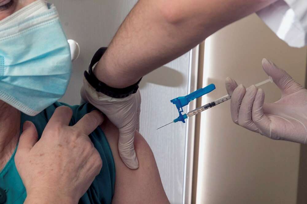 Una sanitaria recibe una dosis de vacuna contra la Covid-19. EFE/Javier Cebollada