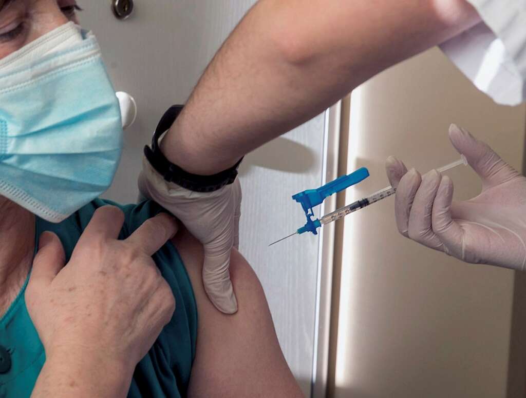 Una sanitaria recibe una dosis de vacuna contra la Covid-19. EFE/Javier Cebollada