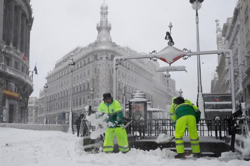 Operarios trabajan para retirar nieve y mejorar la circulación en la Puerta del Sol en Madrid, este sábado. EFE/Ballesteros