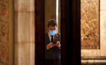 El vicepresidente del Govern con funciones de Presidente, Pere Aragonés, consulta su móvil en los pasillos del Parlament. EFE/Quique García