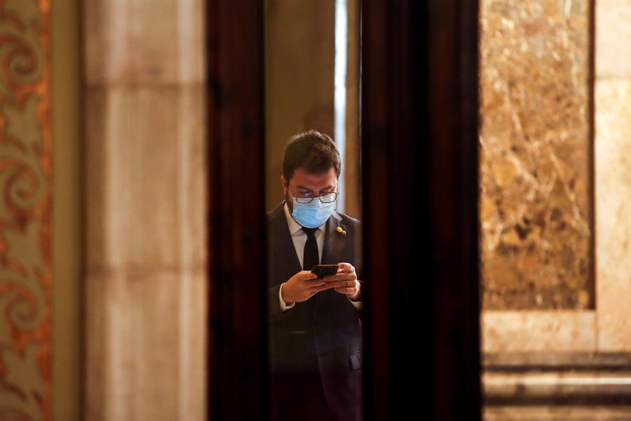 El vicepresidente del Govern con funciones de Presidente, Pere Aragonés, consulta su móvil en los pasillos del Parlament. EFE/Quique García