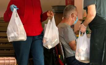 Un grupo de voluntarios participa en un reparto de alimentos a personas en situación de pobreza durante la pandemia de coronavirus. EFE/Cati Cladera