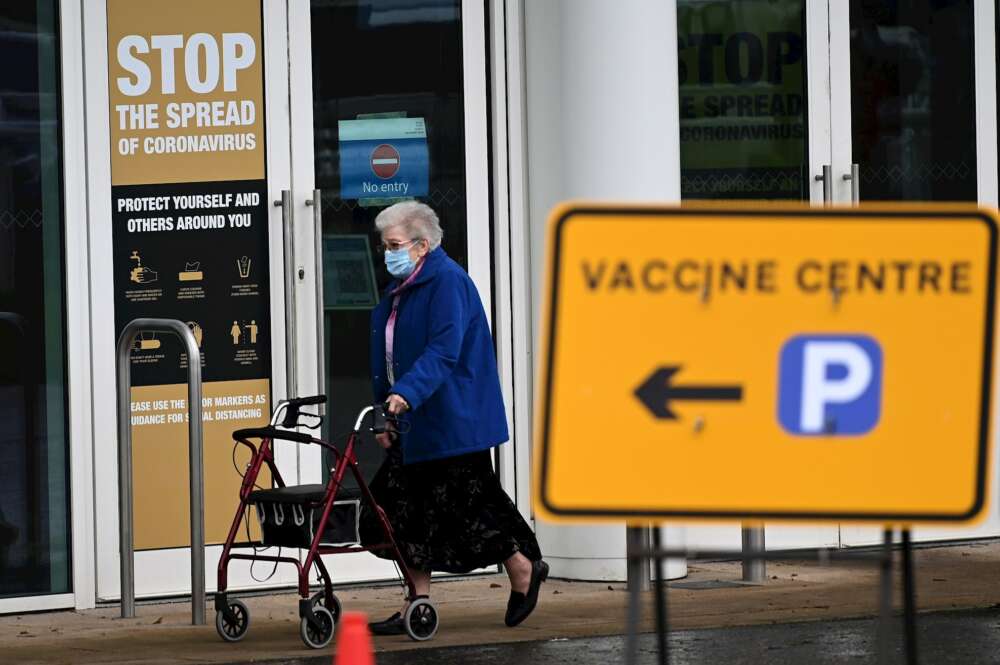 Una mujer sale de un centro de vacunación masiva en Empton, Reino Unido. EFE/ Andy Rain