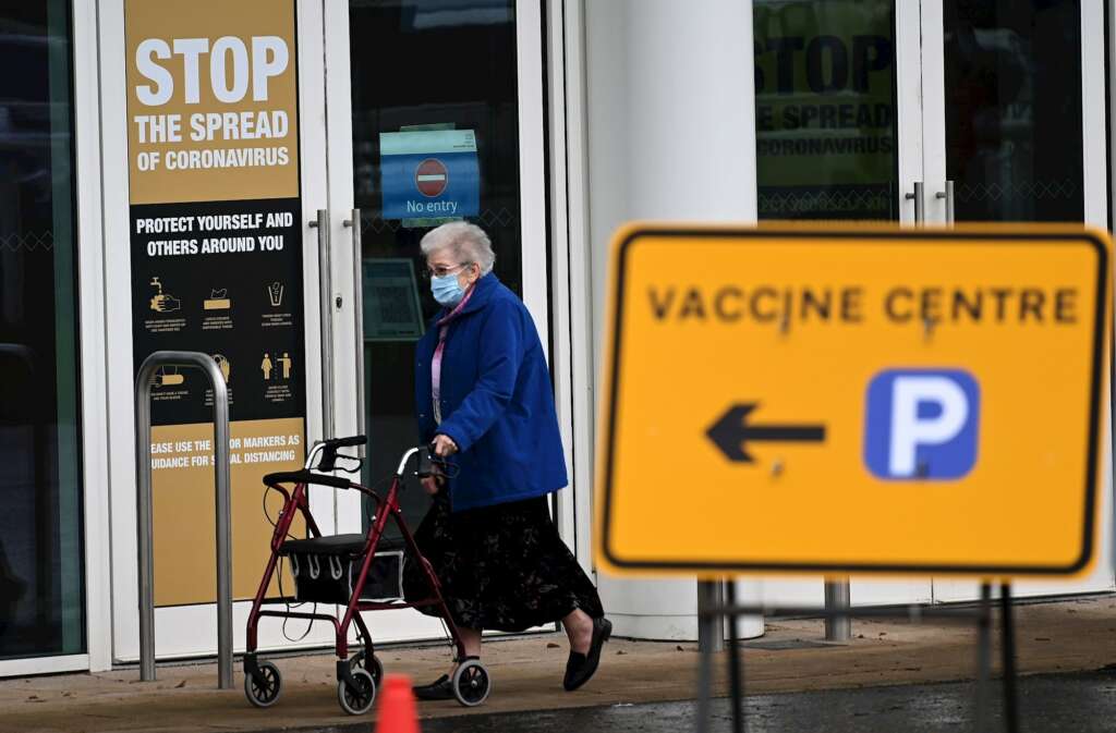 Una mujer sale de un centro de vacunación masiva en Empton, Reino Unido. EFE/ Andy Rain