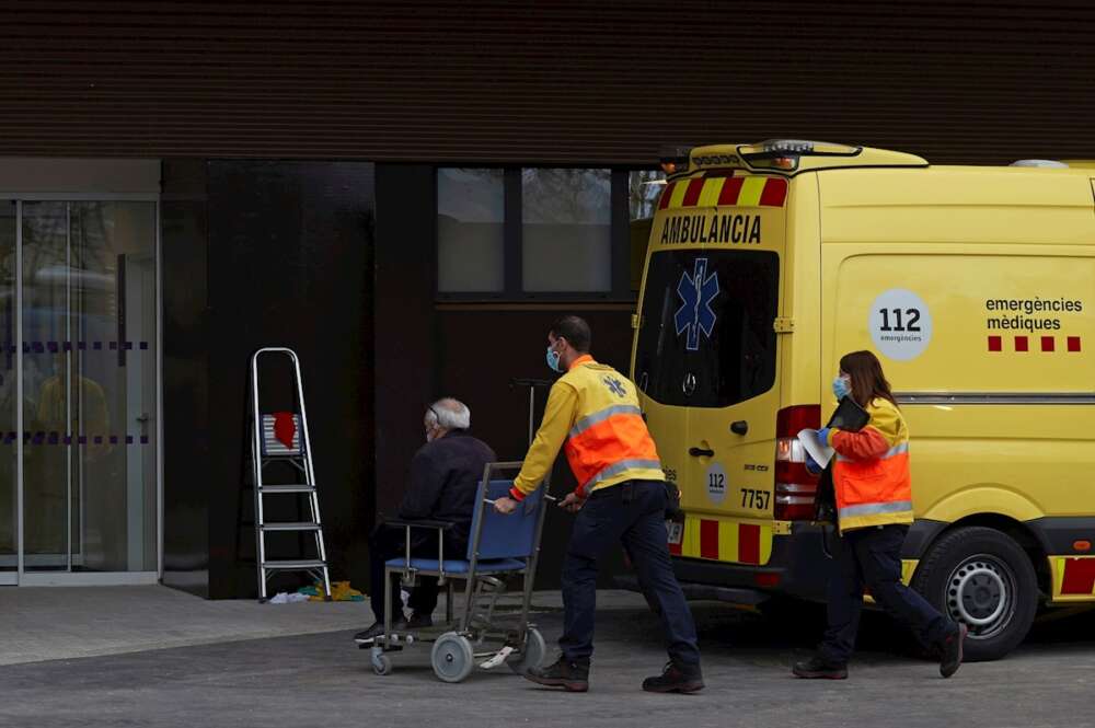 Dos técnicos de emergencias trasladan a un paciente al nuevo "hospital satélite" del Hospital Universitario de Bellvitge este lunes. EFE/Alejandro García