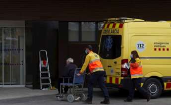 Dos técnicos de emergencias trasladan a un paciente al nuevo "hospital satélite" del Hospital Universitario de Bellvitge este lunes. EFE/Alejandro García