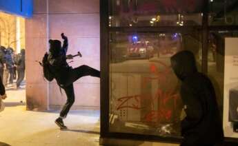 Un joven ataca un comercio durante los disturbios posteriores a la manifestación celebrada este viernes en Girona en protesta por la detención del rapero Pablo Hasél, acusado de delitos de enaltecimiento del terrorismo e injurias a la Corona. EFE/Toni Vilches