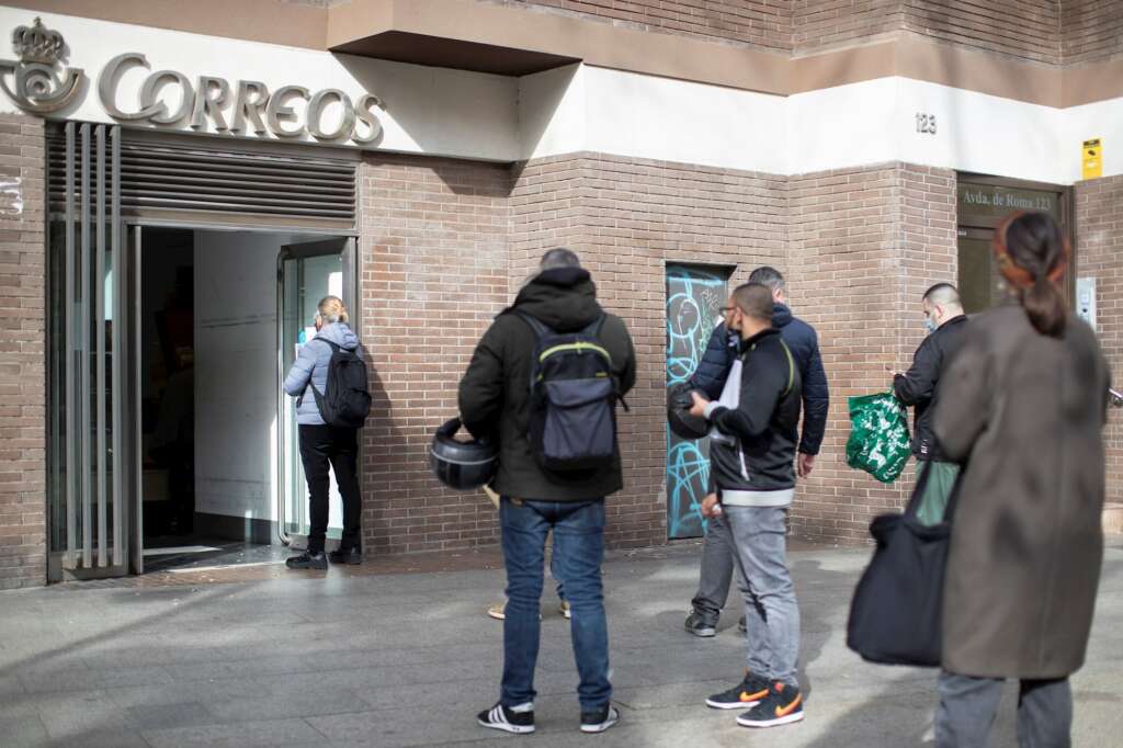 Varias personas hacen cola en una oficina de Correos de Barcelona este viernes, último día para admitir peticiones de voto por correo para el 14F. EFE/ Marta Pérez