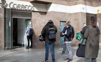 Imagen de archivo de varias personas hacen cola en una oficina de Correos de Barcelona. EFE/ Marta Pérez