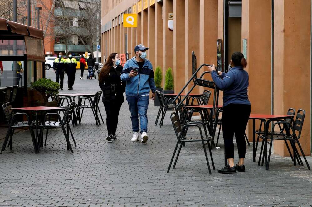 Una camarera prepara la terraza de un restaurante en L´Hospitalet de Llobregat. EFE/Toni Albir/Archivo