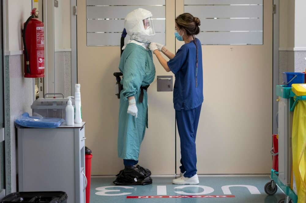 Una enfermera ajusta el Equipo de Protección Personal a un enfermero antes de entrar a un box de la Unidad de Cuidados Intensivos del Hospital Santa Lucia de Cartagena. EFE/Marcial Guillén/Archivo