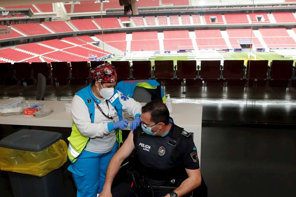 Un policía recibe la primera dosis durante el primer día de vacunación contra la covid-19 en el Wanda Metropolitano. EFE/Juan Carlos Hidalgo