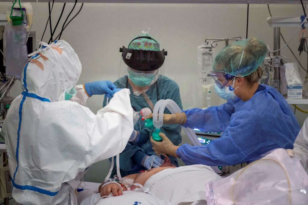 Una doctora y dos enfermeras de la Unidad de Cuidados Intensivos (UCI) del Hospital Santa Lucia de Cartagena atienden a un paciente este sábado. EFE/Marcial Guillén