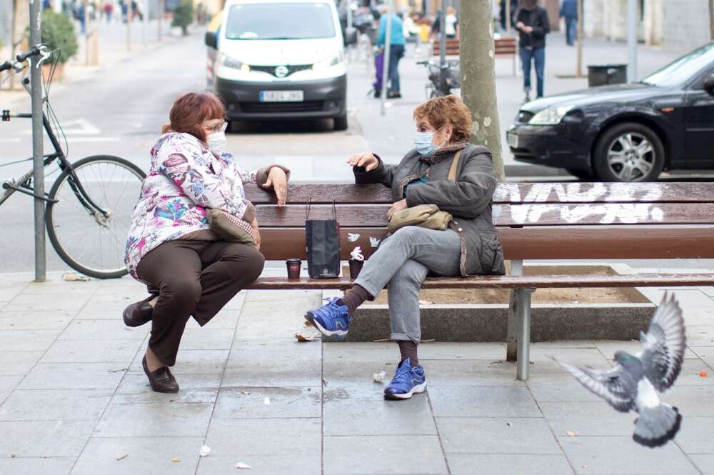 Dos mujeres conversan tomando café en un banco del barrio del Poblenou de Barcelona. EFE/Marta Pérez/Archivo
