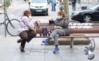 Dos mujeres conversan tomando café en un banco del barrio del Poblenou de Barcelona. EFE/Marta Pérez/Archivo