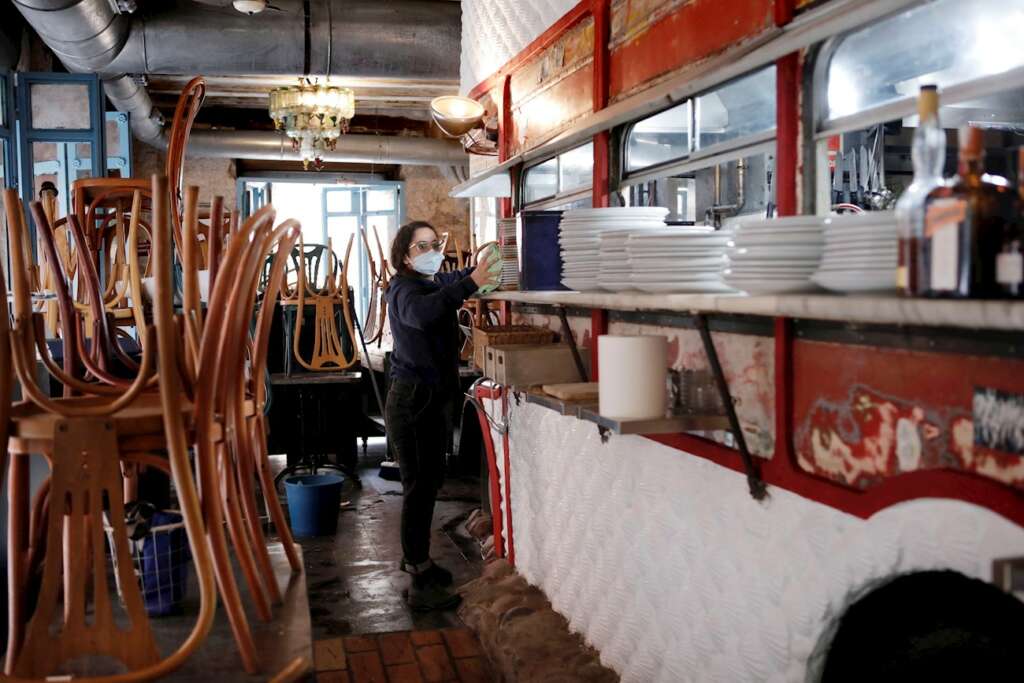 La encargada de un local realiza labores de limpieza y preparación ante la próxima apertura de la hostelería en la Comunidad Valenciana tras el severo plan de restricciones. EFE/ Biel Aliño