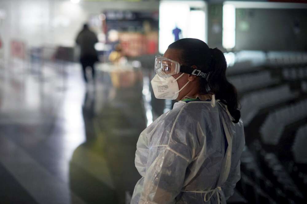 Una mujer con el traje de protección, gafas y mascarilla durante la jornada electoral del 14F. EFE/ David Borrat/Archivo