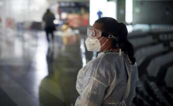 Una mujer con el traje de protección, gafas y mascarilla durante la jornada electoral del 14F. EFE/ David Borrat/Archivo