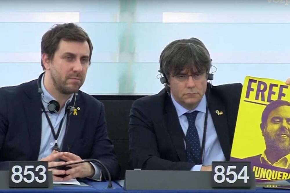 Los eurodiputados independentistas catalanes Toni Comín y Carles Puigdemont izan un cartel con la leyenda "Free Junqueras" en el Parlamento Europeo, el 13 de enero de 2020 | Archivo