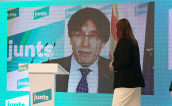 La líder de Junts per Catalunya en el Parlament, Laura Borràs, frente a una pantalla con el prófugo Carles Puigdemont / JxCat