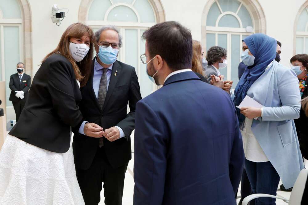 La presidenta del Parlament, Laura Borràs (Junts), abrazada al expresidente Quim Torra, mientras conversa con Pere Aragonès (ERC)