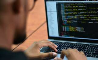 José Pino, hacker colombiano experto en ciberseguridad, revisa algunos códigos en su computador portátil. EFE