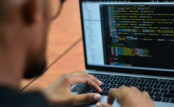 José Pino, hacker colombiano experto en ciberseguridad, revisa algunos códigos en su computador portátil. EFE
