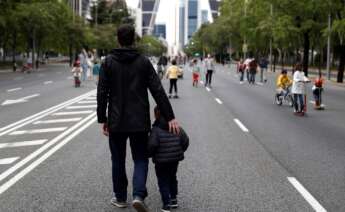 Un hombre pasea con su hijo por el Paseo de la Castellana, en Madrid, durante el primer estado de alarma por coronavirus, en mayo de 2020 | EFE/Mariscal/Archivo