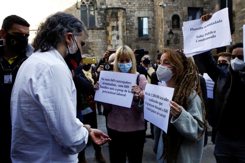 Rastreadores despedidos por la Generalitat abordan a Jordi Cuixart para protestar por su situación laboral en un acto en Barcelona el 29 de enero de 2021 | EFE/QG/Archivo