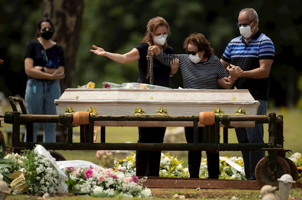 Una familia despide a un familiar durante un entierro en Brasilia (Brasil). EFE/ Joédson Alves.