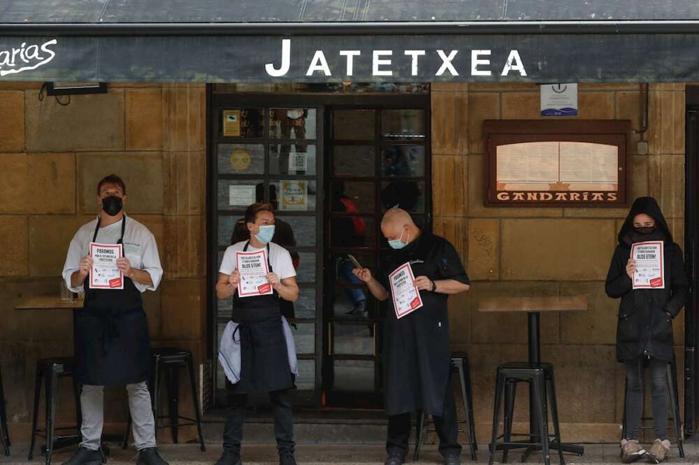 Trabajadores de un restaurante de la Parte Vieja de San Sebastián participan este martes en un paro de 10 minutos para reclamar ayudas de rescate. EFE/Juan Herrero