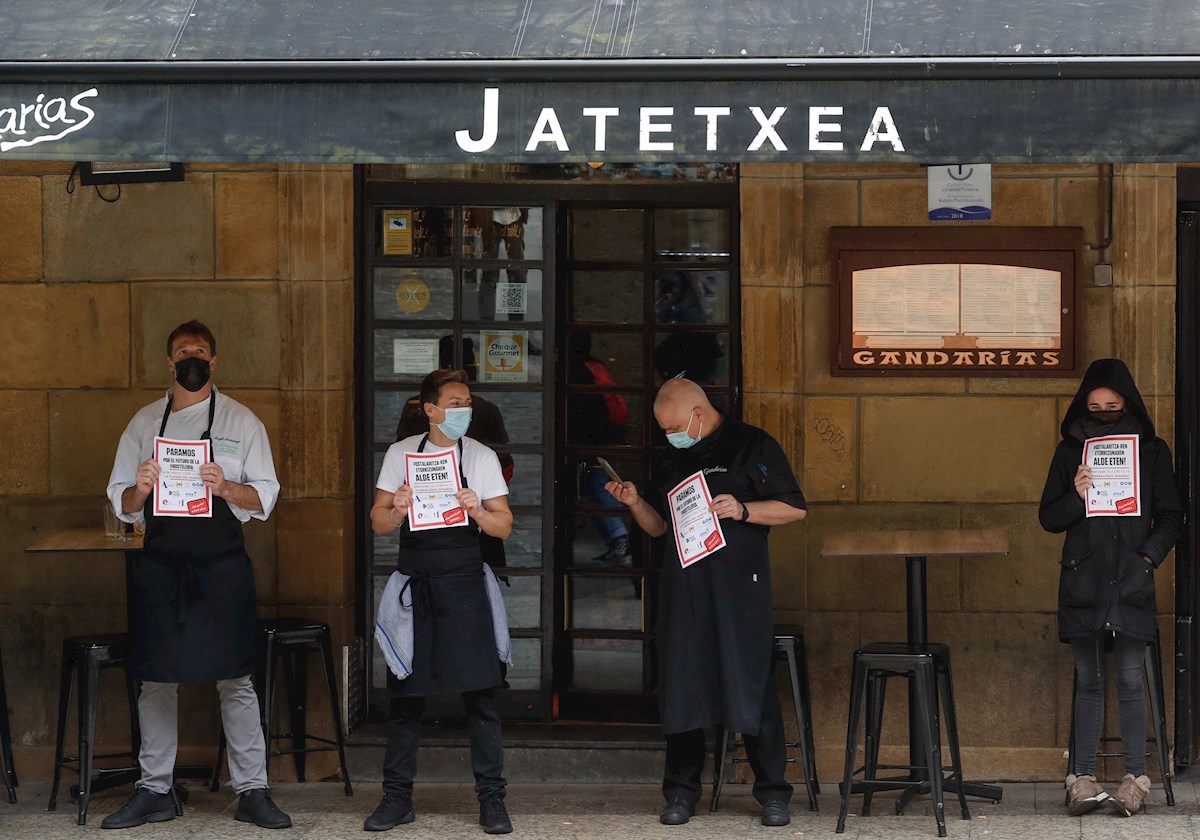 Trabajadores de un restaurante de la Parte Vieja de San Sebastián participan este martes en un paro de 10 minutos para reclamar ayudas de rescate. EFE/Juan Herrero