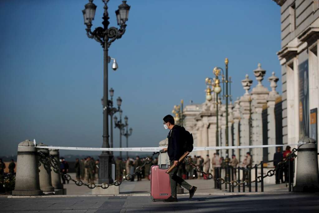 Un joven con su maleta pasa ante el Palacio Real de Madrid. EFE/ Juan Carlos Hidalgo/Archivo