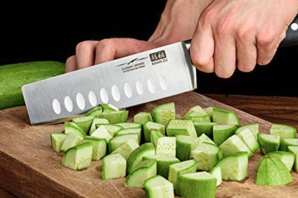 El cuchillo japonés de Amazon mientras corta verduras