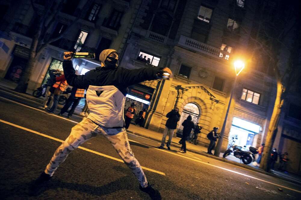 Un manifestante se dispone a lanzar una botella a la policía durante la protesta contra la detención y prisión del músico y rapero Pablo Hasel. EFE