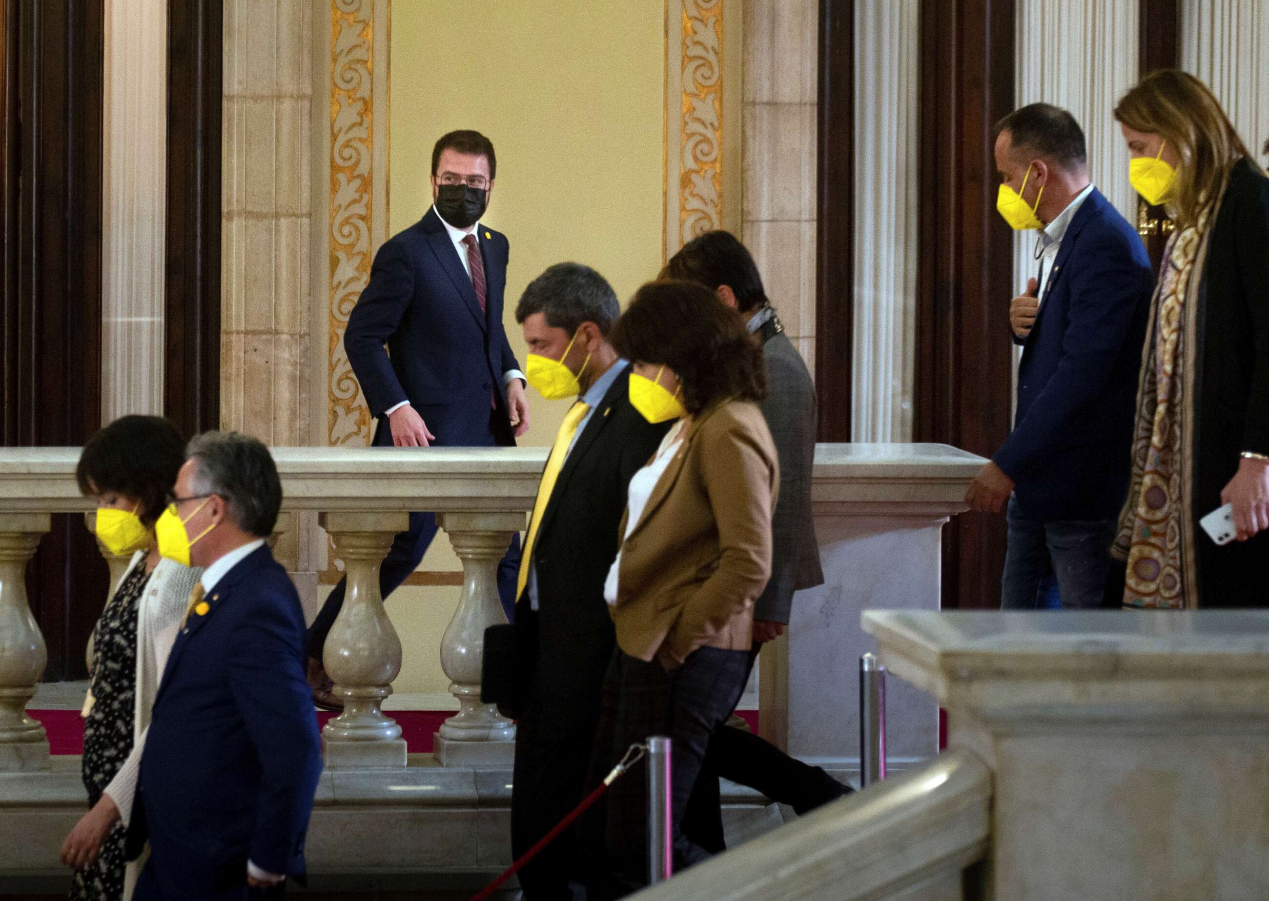 El candidato de ERC, Pere Aragonés, junto a varios diputados de JxCat, en los pasillos del Parlament durante un receso del debate de investidura del nuevo presidente de la Generalitat que se celebra este viernes en el Auditori del Parlament de Catalunya. EFE/Enric Fontcuberta