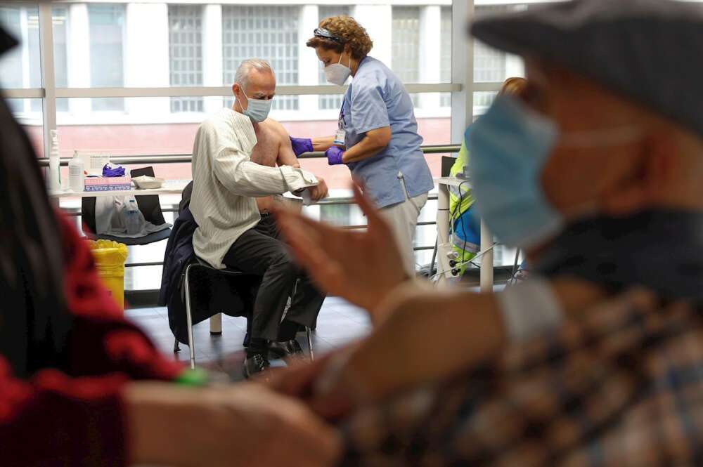 Varias personas reciben sus respectivas dosis de vacuna en el Wizink Center de Madrid. EFE/ Emilio Naranjo