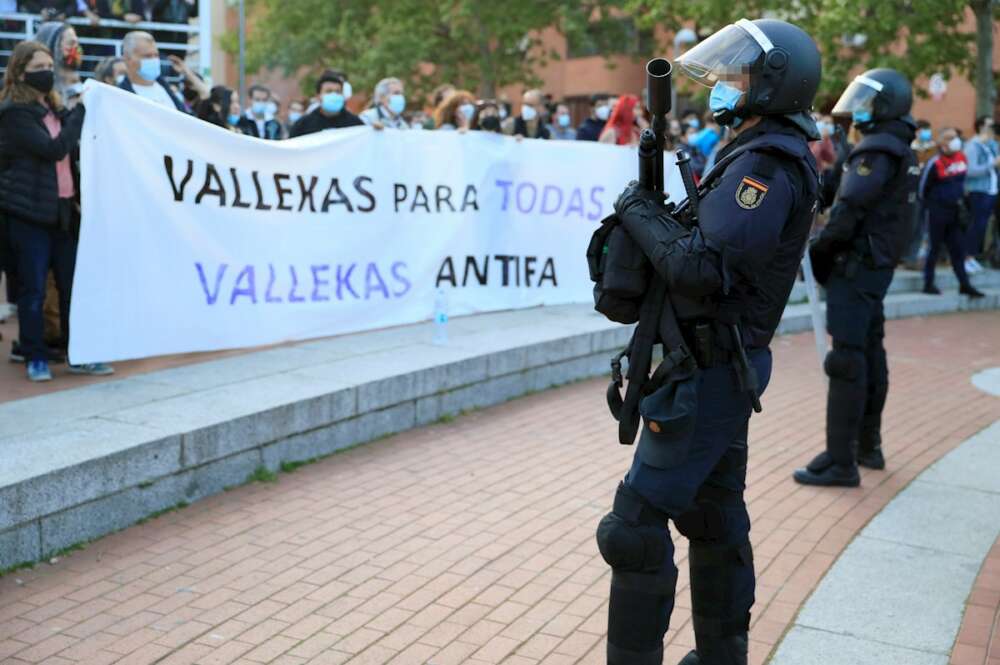 La Policía Nacional junto a los manifestantes congregados en Vallecas para protestar por el acto de precampaña de Vox, algunos de los cuales han lanzado botellas y otros objetos contra el líder nacional del partido, Santiago Abascal, y la candidata para las elecciones de esa formación en la Comunidad de Madrid, Rocío Monasterio, a su llegada. EFE/Fernando Alvarado