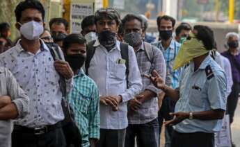 Los indios con mascarillas protectoras hacen cola mientras esperan el autobús en una parada de autobús en Mumbai, India, el 30 de abril de 2021. India ha registrado recientemente un aumento masivo de casos y muertes por COVID-19, el aumento más alto en un día desde que el comienzo de la pandemia. EFE / EPA / DIVYAKANT SOLANKI