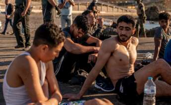 Varios migrantes descansan en la playa ceutí de El Tarajal tras alcanzar la costa española este miércoles. Tercer día de tensión en la frontera de Ceuta con Marruecos, después de la entrada ilegal en la ciudad autónoma de más de 8.000 personas y con el Ejército y las fuerzas de seguridad desplegados en la zona. EFE/Brais Lorenzo